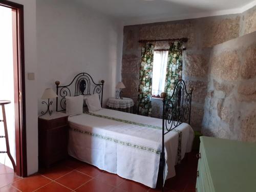 a bedroom with a bed and a window at A casa do pátio in Montalegre