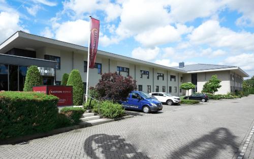 a building with a car parked in front of it at Bastion Hotel Schiphol Hoofddorp in Hoofddorp