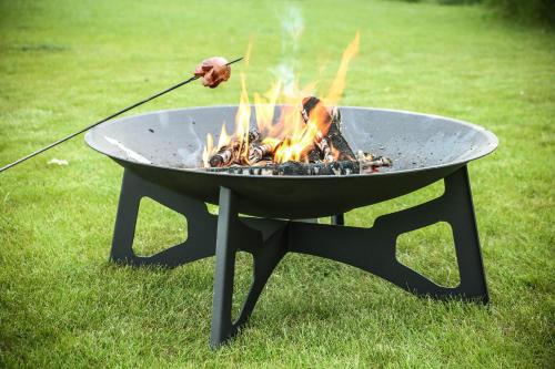 a person is stirring a grill with a stick at Penzion Betlém in Hlinsko