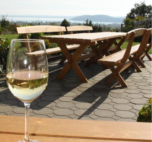 a glass of wine sitting on a table with a bench at Koczor Winery & Guesthouse in Balatonfüred