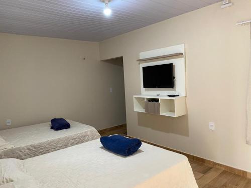 a room with two beds and a tv on the wall at Casa Ondas de Alter in Alter do Chao