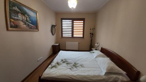 sypialnia z dużym łóżkiem z białą pościelą i oknem w obiekcie Topas w Gdańsku