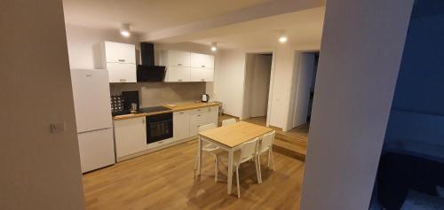 a kitchen with white cabinets and a table and chairs at Dom Pod Groniem in Rzyki