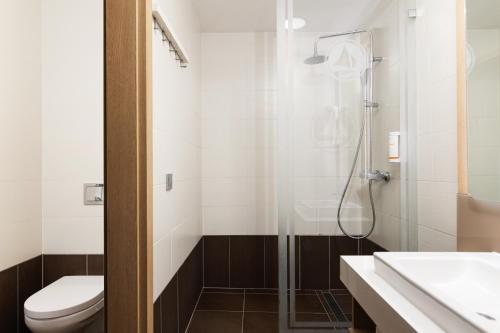 uma casa de banho com um chuveiro, um WC e um lavatório. em Portobello Wellness & Yacht Hotel Esztergom em Esztergom