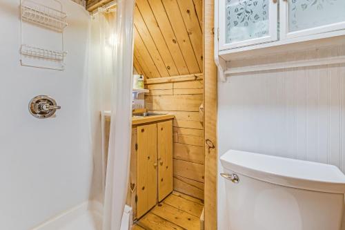 a bathroom with a toilet and a wooden wall at Sunny Acres Cabin in Moab