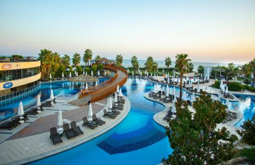 an aerial view of a resort pool with chairs and palm trees at Sherwood Dreams Resort in Belek