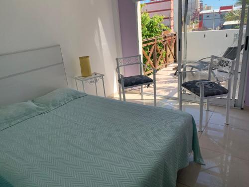 1 dormitorio con 1 cama y 2 sillas en el balcón en Brisas 1 en Santa Teresita