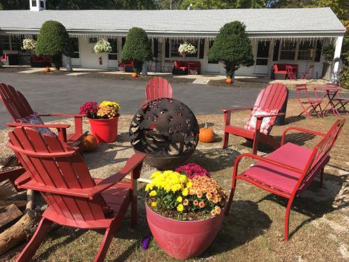 a group of red chairs and flowers in a yard at Starlight Lodge North Conway in North Conway