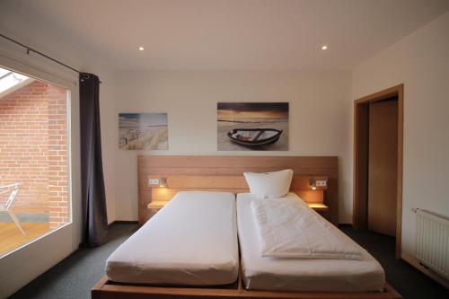 a large bed in a room with a window at Hotel Zur Linde in Hechthausen