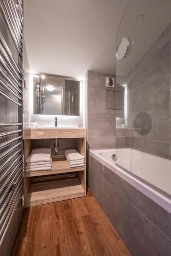 a bathroom with a sink and a bath tub at Vacancéole - Résidence La Duit in La Léchère