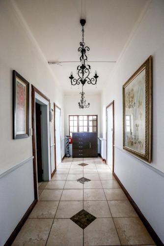 a hallway with a chandelier and a tile floor at Misty Waves Boutique Hotel in Hermanus