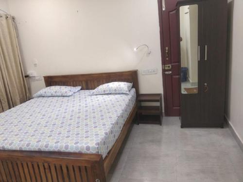 a bedroom with a wooden bed and a bathroom at Nature Villa Kochi in Alwaye