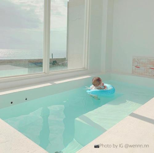 a baby sitting on a raft in a swimming pool at Whitelance B&B in Manzhou