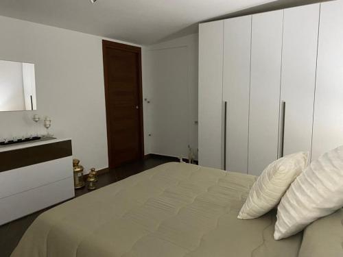 a white bedroom with a large bed with white cabinets at B&B Le Rocce in Castel San Giorgio