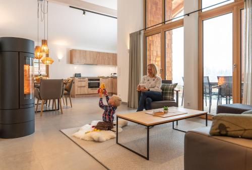 a woman sitting in a living room with a child at Luxury Chalets Gradenbach near Schladming in Haus im Ennstal