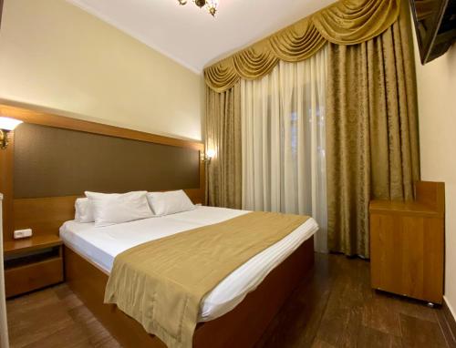 a bedroom with a large bed and a window at Boomerang Business Hotel in Odesa