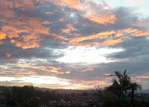 un cielo nuvoloso con una palma e un tramonto di Acogedor Apartamento en Centro de Popayán a Popayan