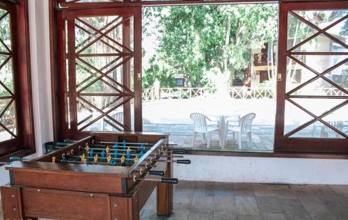 a room with a foosball table and some chairs at Apartamento completo perto da Praia de Maresias in São Sebastião