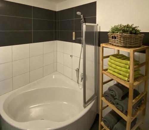 La salle de bains est pourvue d'une baignoire, d'une douche et de serviettes. dans l'établissement Ferienwohnung Bernadette, à Goldegg