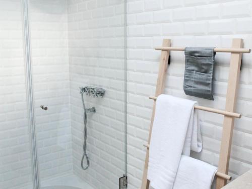 La salle de bains est pourvue d'une douche avec du carrelage blanc. dans l'établissement Sao bento stylish cozy apt with ac balcony, à Lisbonne