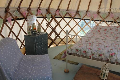 a room with a bed and a chair in a yurt at Mill Haven Place glamping-yurt 2 in Haverfordwest