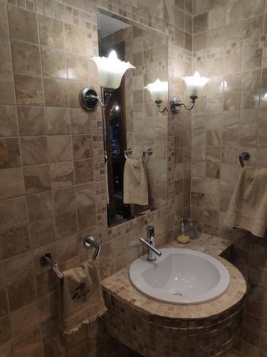 uma casa de banho com lavatório, espelho e toalhas em British Wood 'n Stone House em Tessalônica