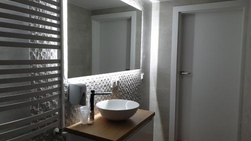 a bathroom with a bowl sink and a mirror at Dom Pod Groniem in Rzyki