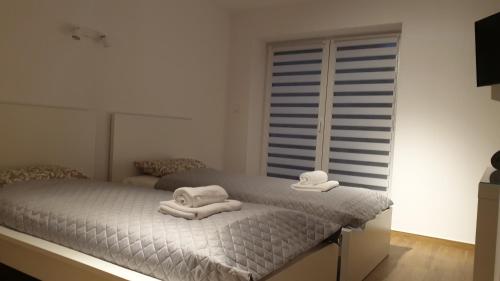 a bedroom with a bed with towels on it at Dom Pod Groniem in Rzyki