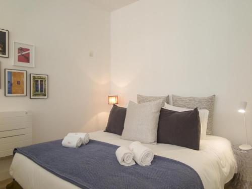 um quarto com uma cama grande e toalhas em Chiado bright modern apt with ac elevator em Lisboa