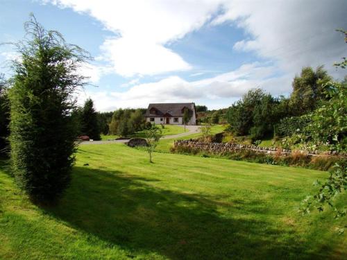 una casa en medio de un campo verde en Binnilidh Mhor B&B en Glenmoriston