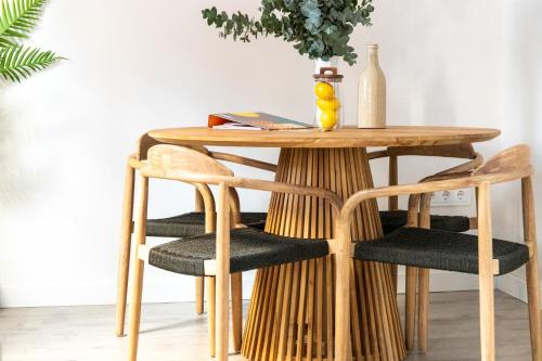 einen Esstisch und Stühle mit einem Holztisch in der Unterkunft Tinto Townhouse by Olala Homes in Sevilla