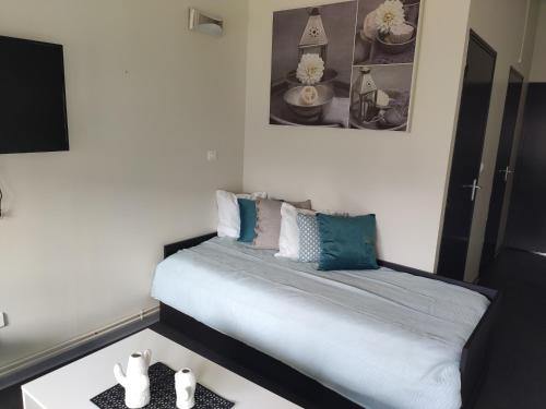 a small bedroom with a bed and a table at Centre Bol Vert in Trélon