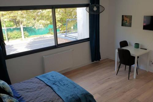 une chambre avec un lit, un bureau et une fenêtre dans l'établissement studio 4 Henriville, à Amiens