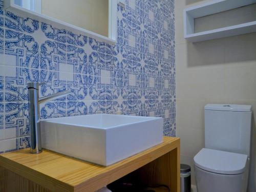 a bathroom with a white sink and a toilet at Mouraria lovers cozy bright apartment in Lisbon