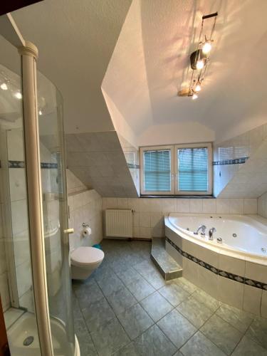 a large bathroom with a tub and a toilet at Haus Belger in Großziethen