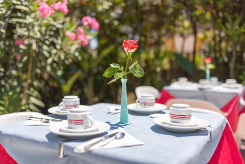 a table with a red rose in a vase on it at La Piramide in Roccalumera