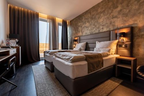 a hotel room with two beds and a desk at Nutrend World in Olomouc