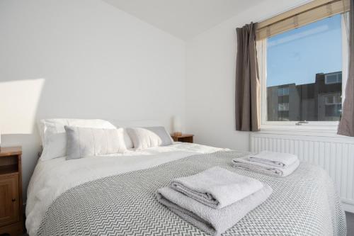 Un dormitorio blanco con una cama con toallas. en Dwellcome Home Ltd 2 Bed Aberdeen Apartment - see our site for assurance en Aberdeen