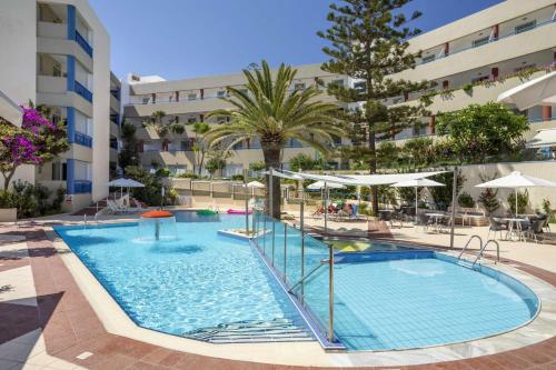 a large swimming pool in a building with a resort at Ibiscos Garden Hotel in Rethymno