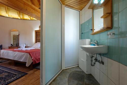 een badkamer met een wastafel en een bed in een kamer bij Villa Spyridoula studios on the Beach in Sidari