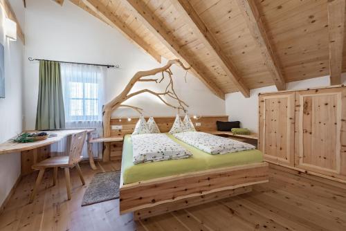 ein Schlafzimmer mit einem Bett in einem Zimmer mit einem Schreibtisch in der Unterkunft Platzbon in Brixen