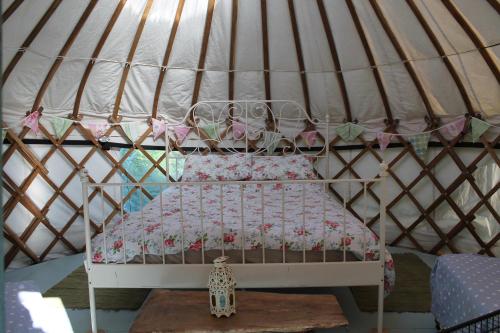 a small bed in a yurt with a canopy at Mill Haven Place glamping yurt 3 in Haverfordwest