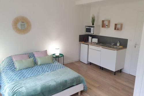 une petite chambre avec un lit et une cuisine dans l'établissement studio 3 Henriville, à Amiens