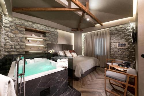 a hotel room with a bed and a tub at Tsikeli Boutique Hotel Meteora - Adults Friendly in Kalabaka