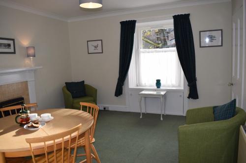 a living room with a table and chairs and a window at 3 St Gilbert Street in Dornoch