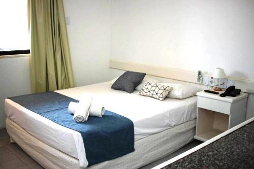 um quarto com uma cama grande e um cobertor azul em Hotel Amarração em Luís Correia
