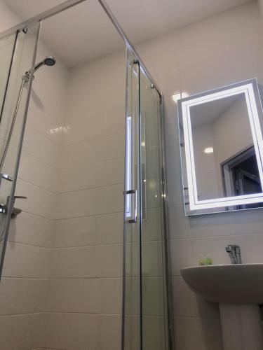 a bathroom with a glass shower and a sink at Park Hotel in Nizhyn