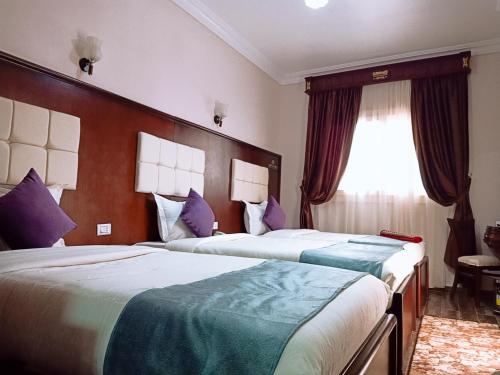 a hotel room with two beds and a window at Grand Hotel Ras Elbar in Ras El Bar