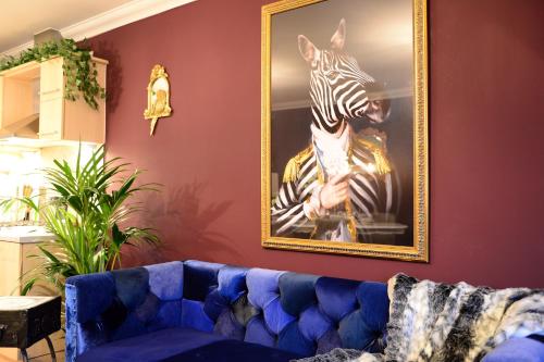 a painting of a zebra on a wall with a blue couch at 2 Bedroom Apartment - Disc0unts - Parking, Contractors, Group, Family in Canterbury