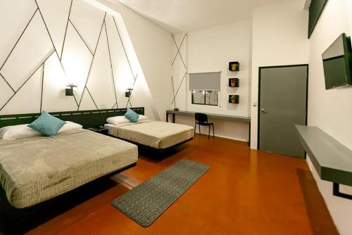 1 dormitorio con 2 camas, mesa y espejo en D' LA TORRE HOTEL, en Managua
